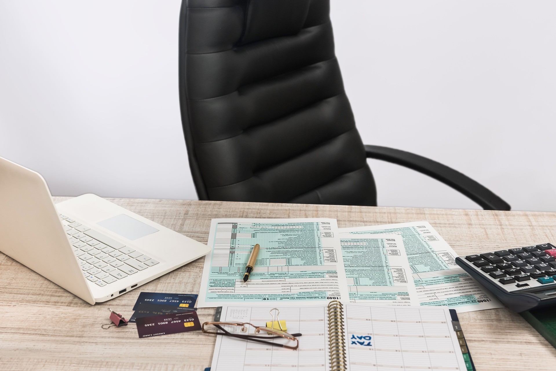 Accountant office - 1040 U.S tax forms April 15 of the deadline time, laptop, money and pen.