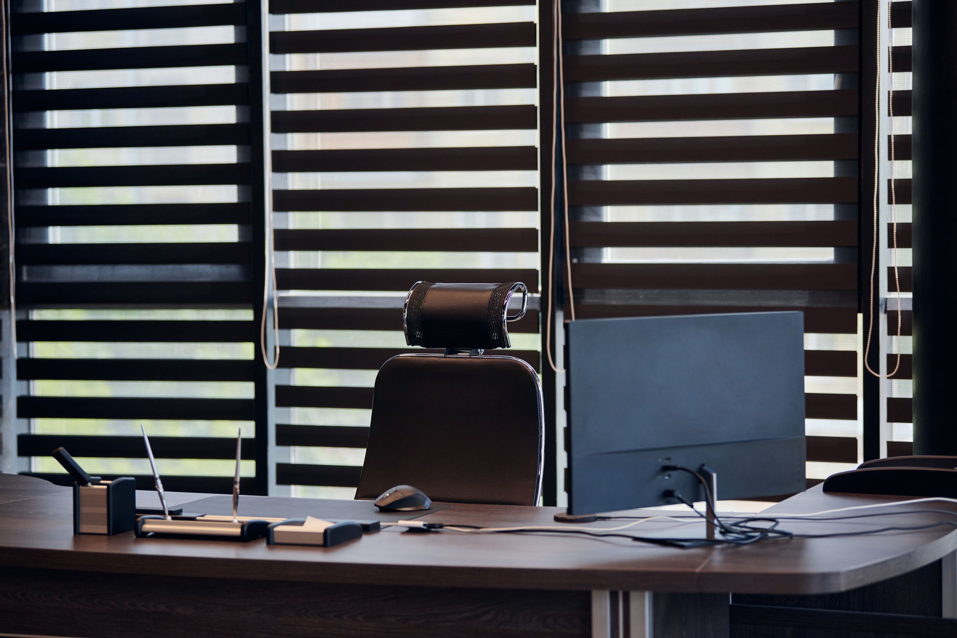 Business office workplace. Work place for chief, boss or other employees. Table and comfortable chair. Light through the half open blinds